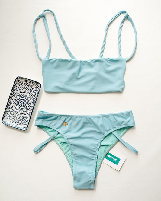 Sky blue Palm bikini top with a tie-back feature and Tobago bottoms with strappy side details, presented with a phone case for a complete summer look.