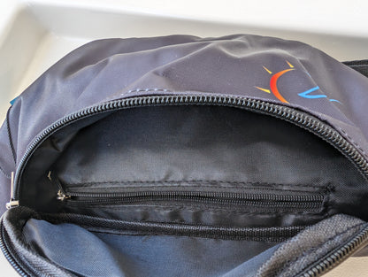 Open view of the black fanny pack's interior compartment with sublimated logo on the front.