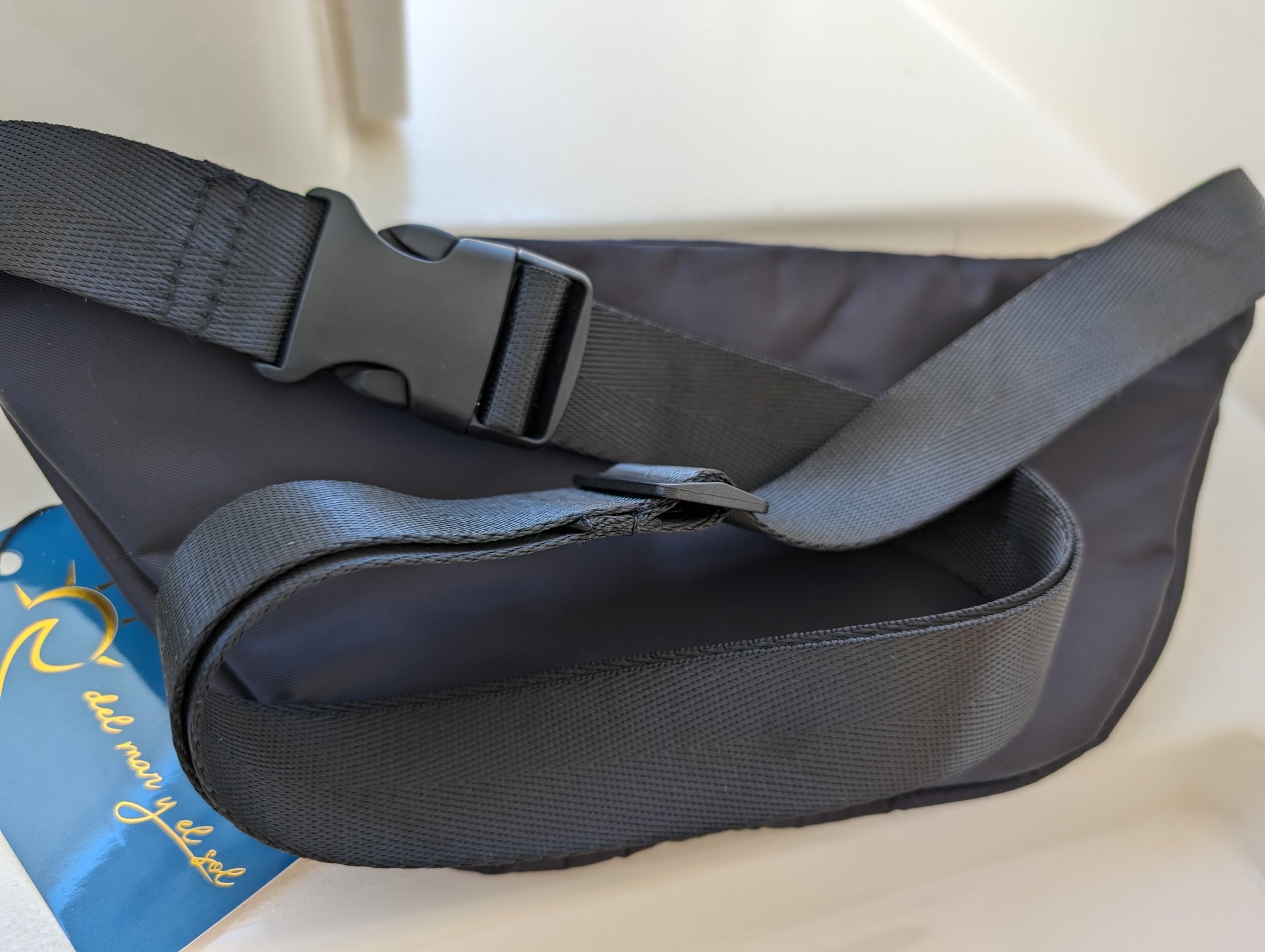 Close-up of the black fanny pack's adjustable strap and buckle detail.