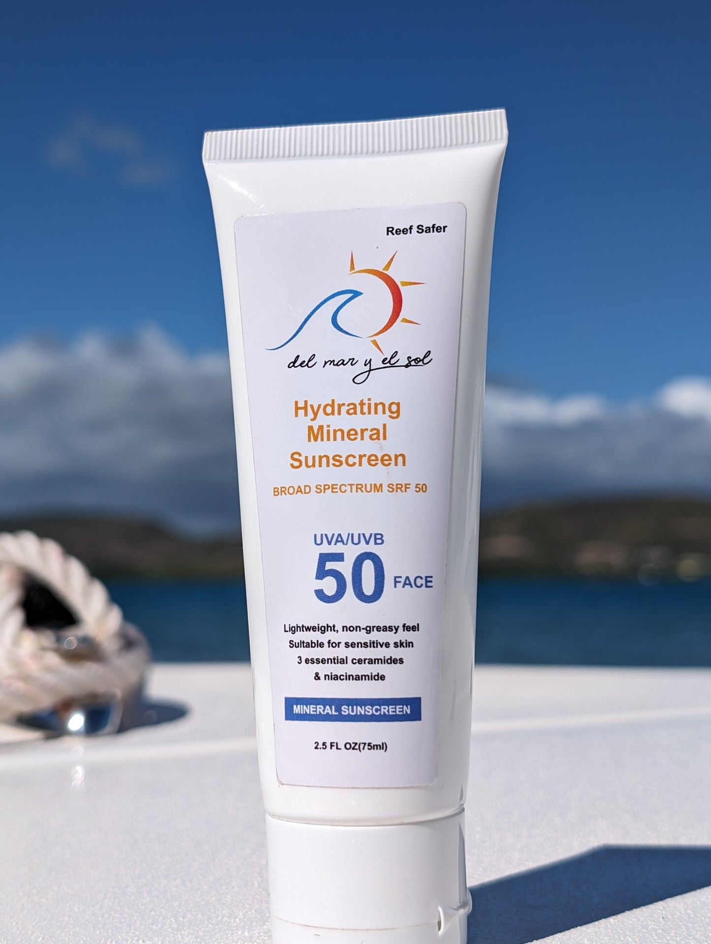 Close-up of Del Mar y el Sol SPF 50 Face Sunscreen on boat deck with nautical ropes and sea in the background.