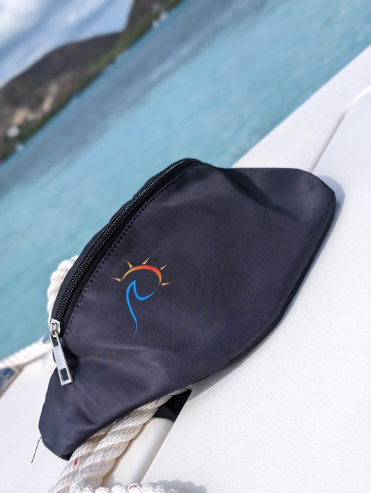 Angled side view of the black fanny pack with a sublimated logo, resting on a boat's edge