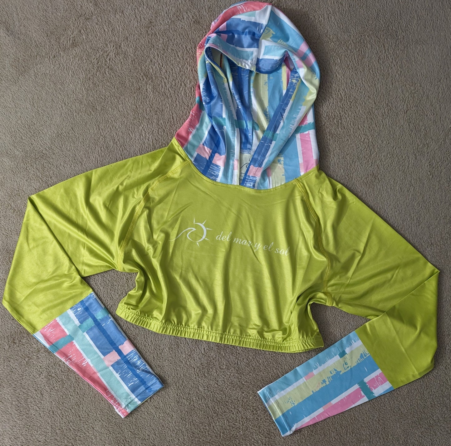 Vibrant lime green cropped rash guard with pastel striped sleeves and hood.