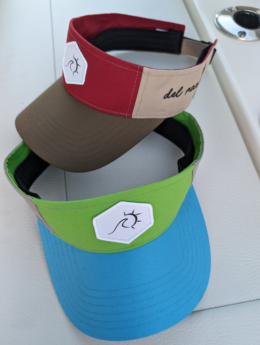 Adjustable Del Mar visor in multiple colors with Velcro strap and embroidered logo, made from 100% polyester