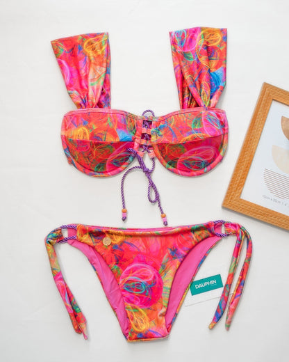 Vibrant Belice underwire tie-back bikini top and Calypso side-tie bottoms set, displayed with a tropical pattern and artistic frame, embodying beach-ready vibrance.