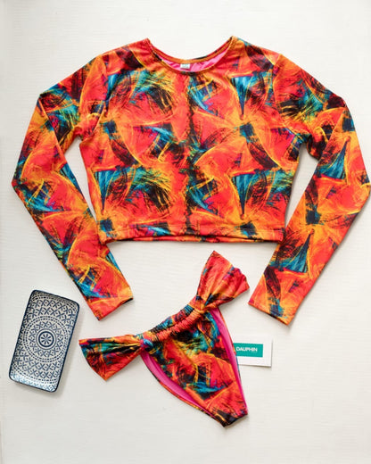 Abstract printed ‘Surf Life’ long sleeve crop top paired with fashion detail ‘Fiji’ bikini bottoms, displayed with a phone case, symbolizing a vibrant beach lifestyle.