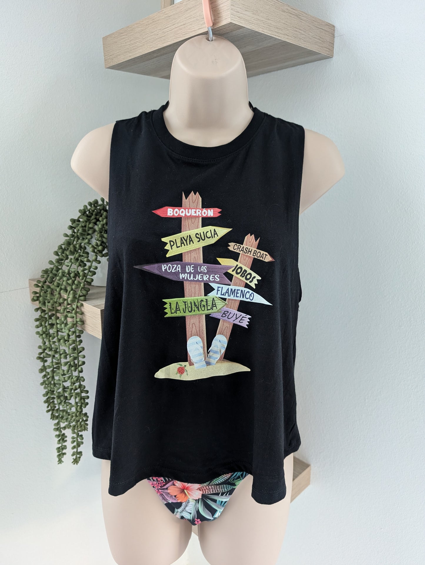 Black tank top with colorful graphic design on a mannequin against a light gray background.