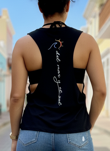  A woman standing on a street with a black tank top with the logo and the brand name on the back