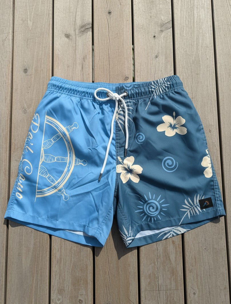 Blue Caribbean-inspired men’s beach shorts with elastic waist, side pockets, and contrasting tropical artwork