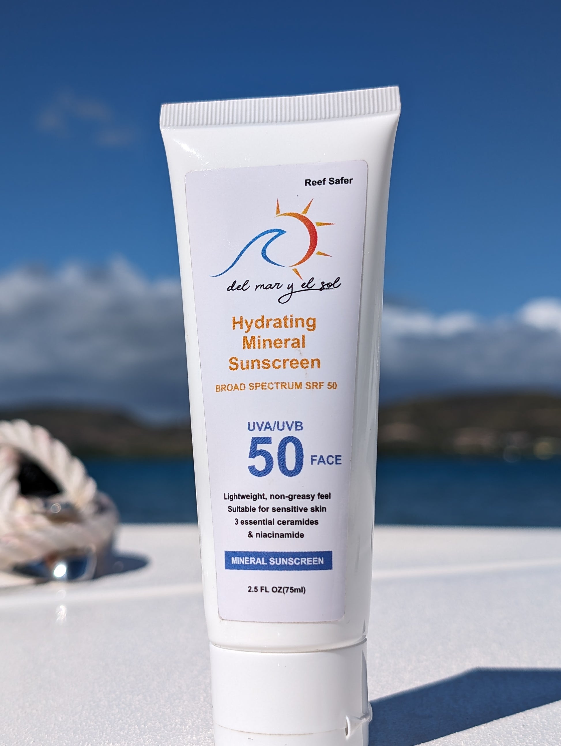 Close-up of Del Mar y el Sol SPF 50 Face Sunscreen on boat deck with nautical ropes and sea in the background.