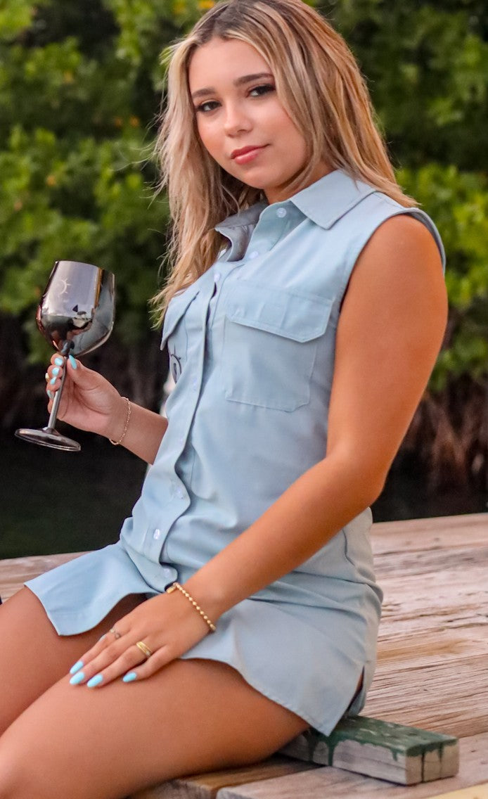 A woman in a fog green, sleeveless mini quick dry button dress.