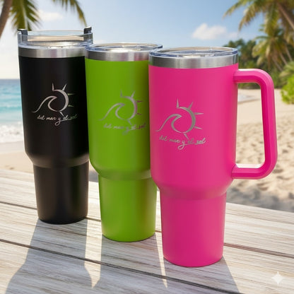 Three colorful tumblers (black, green, pink) with a logo of a sun and wave on a wooden surface with a beach background.