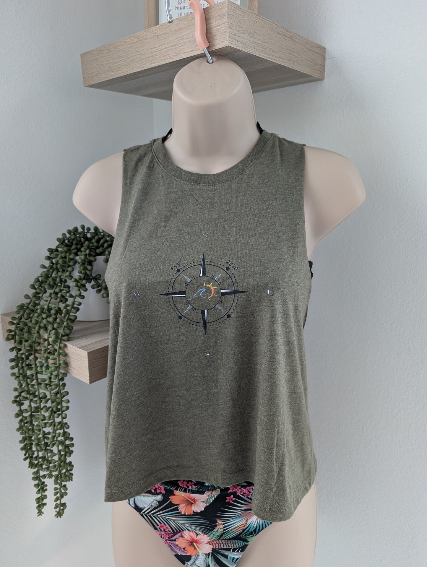 Mannequin wearing a green tank top with a compass design