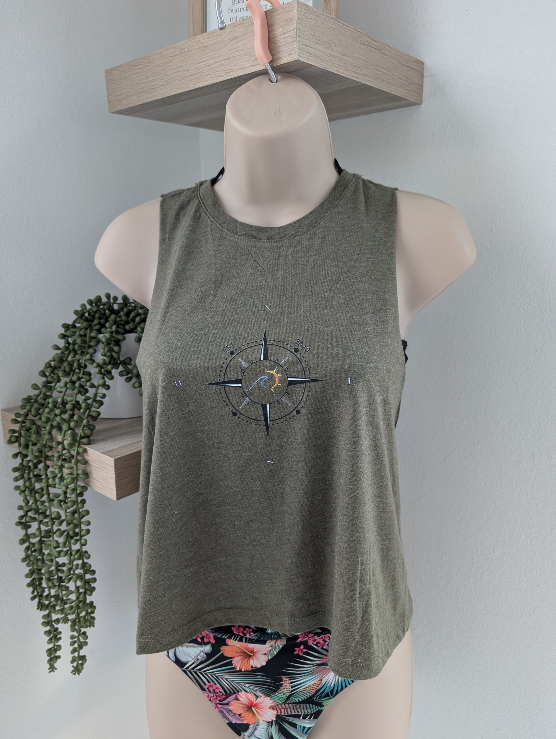 Mannequin wearing a green tank top with a compass design