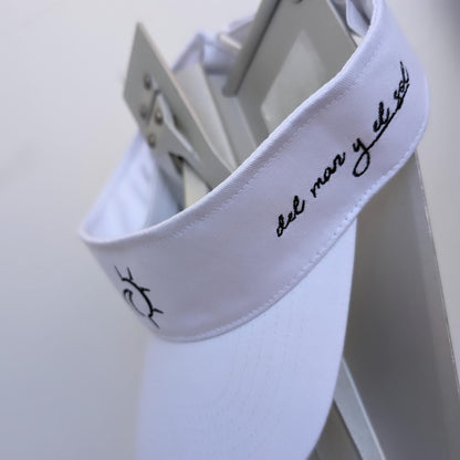 A white visor hat with black text and embroidery, featuring an adjustable velcro strap.