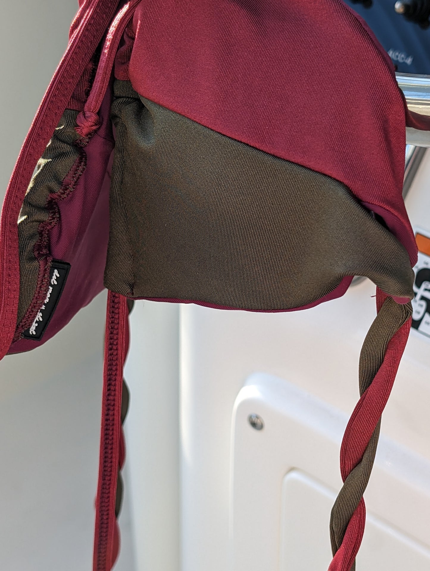 Detailed view of the bikini top’s side showing the braided strap and brand tag