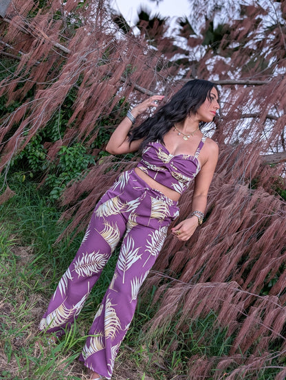 Model wearing Isla Palm Pants with tropical print, wide-leg design, and comfortable elastic waistband.