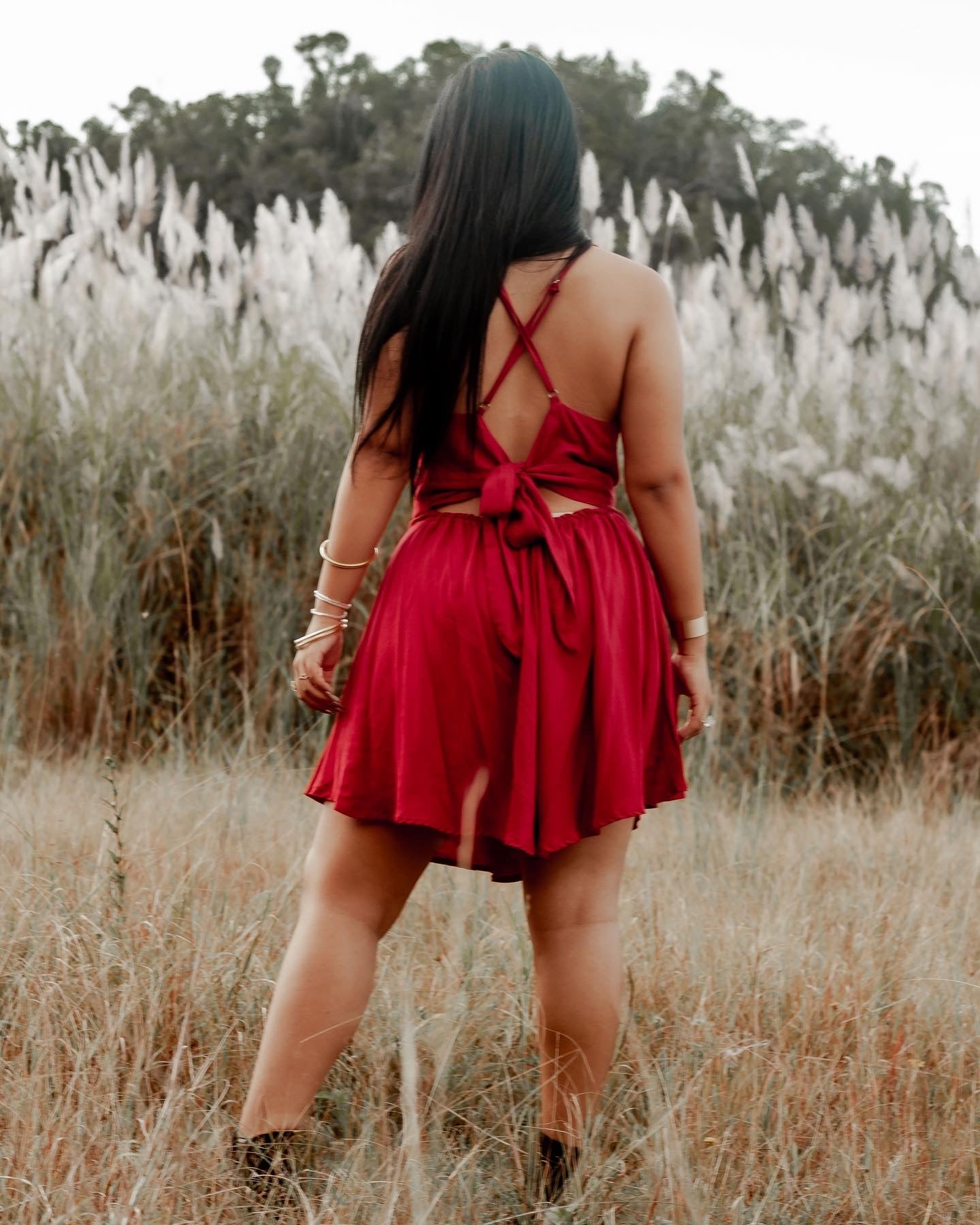 Short elegant red dress with adjustable straps styled for a casual chic tropical look