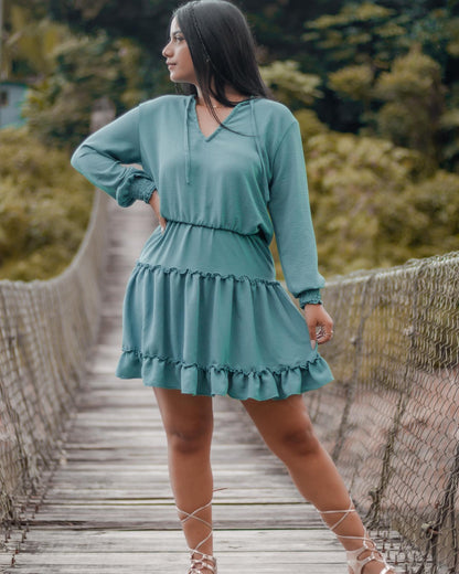 Woman wearing a structured linen romano midi dress with long sleeves and elastic waist, styled in an elegant coastal fashion look